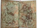 an open book with a floral design on the cover