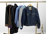 a rack with clothes and a skateboard on it