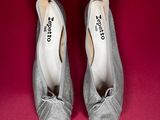 pair of silver shoes on a red surface