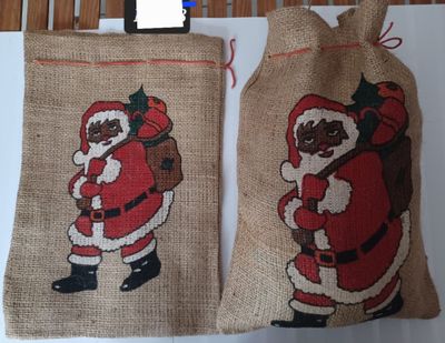 two bags with santa claus on them hanging on a wall