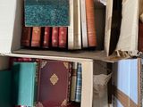 many books stacked on top of each other in a box