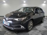 La Toyota Corollant est garée dans une grande pièce au sol carrelé en damier.