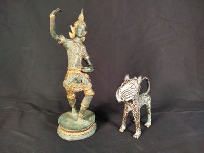 deux statues représentant un homme et un chien sur fond noir