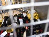 many bottles of wine sitting in a metal basket