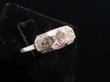a close up of a diamond ring on a velvet surface