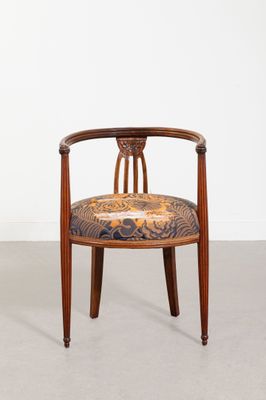 une image d'une chaise en bois dont l'assise est recouverte d'un rembourrage floral