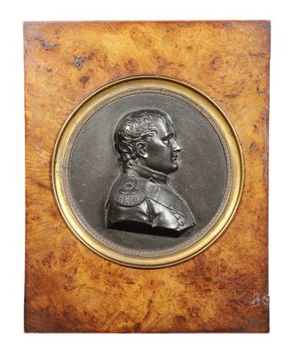 a bronze portrait of a man with a beard in a wooden frame