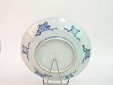 two blue and white plates with designs on them