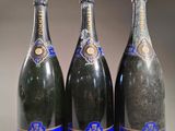 trois bouteilles de champagne posées côte à côte sur une table