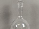 une carafe en verre posée sur une table, sur fond blanc
