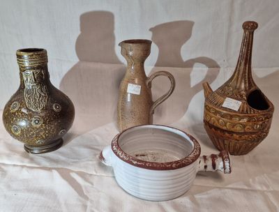 three vases and a bowl sitting on a table