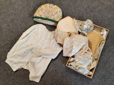 a box full of clothes and a hat on the floor