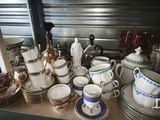 many cups and saucers sitting on a table
