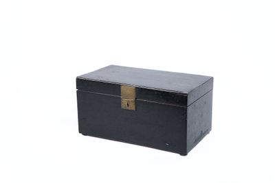 une petite boîte noire sur laquelle est accrochée une étiquette dorée