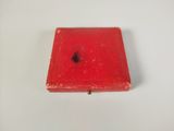 a close up of a small red box on a white surface