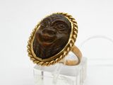 une image représentant une bague en or sur laquelle est gravé un visage