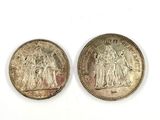two silver coins, one of which is a woman and one of which is a man