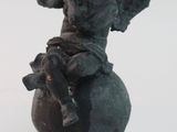 une statue représentant un ange assis sur une boule