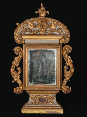 un miroir avec un cadre doré sur fond noir