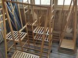 many wooden chairs in a room with a window in the background