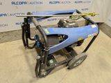 une machine bleue posée sur un sol en béton, près d'un mur