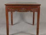 une petite table en bois avec un plateau en marbre sur fond gris
