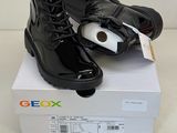 une paire de bottes noires posée sur une boîte blanche