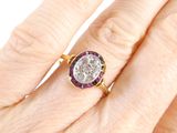 an image of a close up of a person ' s hand with a diamond and ruby ring