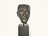 bronze sculpture of a man ' s face on a black base