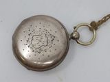 a silver pocket watch with a chain around it