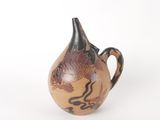 un petit vase orné d'un poisson, posé sur un fond blanc