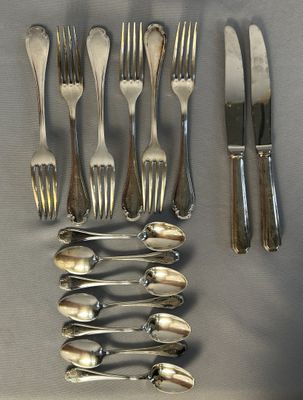 a lot of forks and spoons laid out on a table