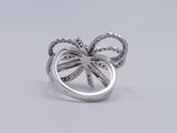 sterling silver ring with a bow and diamonds on a white background