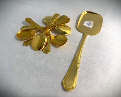 a gold spoon and a gold spoon with a flower on it