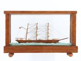 une petite maquette de bateau en bois exposée dans une vitrine