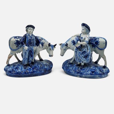 pair of blue and white porcelain figurines of a man and a woman on horses