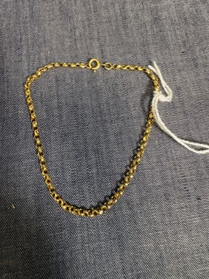 un bracelet en chaîne d'or avec des perles noires et un cordon blanc