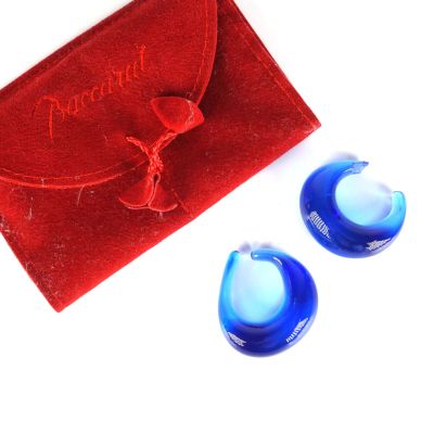 une paire de bouchons d'oreille en verre bleu dans une pochette en velours rouge