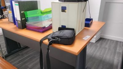 a bag sitting on top of a desk next to a computer monitor