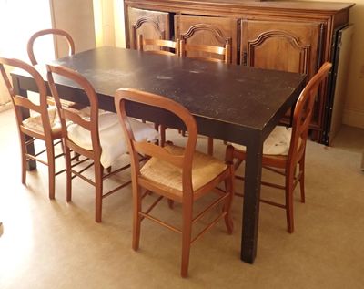 une table de salle à manger avec quatre chaises et une commode en arrière-plan