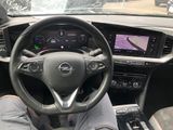 someone is sitting in the driver ' s seat of a car with their feet on the steering wheel