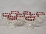 six wine glasses with red and gold designs on them sitting on a table