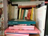 a stack of books on a shelf next to a book case