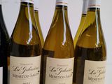 six bottles of wine are lined up in a row on a table