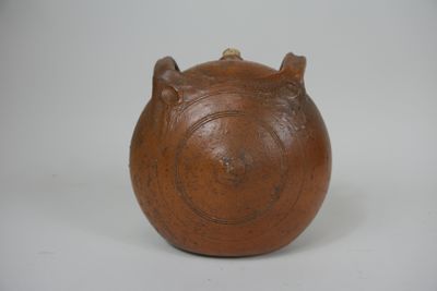 un petit vase marron orné de deux cornes
