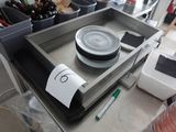un plateau en métal sur lequel est posée une assiette, posé sur une table