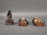 three small figurines of a man and a woman sitting on top of a table
