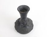 a black vase that is sitting on a white surface