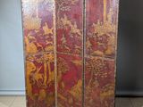 un vieux paravent rouge et or orné de motifs asiatiques