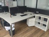 un bureau blanc sur lequel sont posés deux écrans d'ordinateur